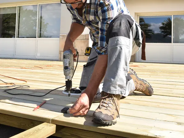 A contractor installing pressure treated decking boards