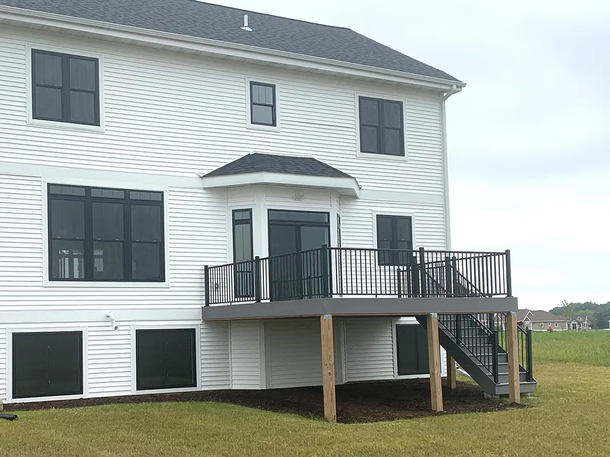 Large home with an elevated deck with black metal railing