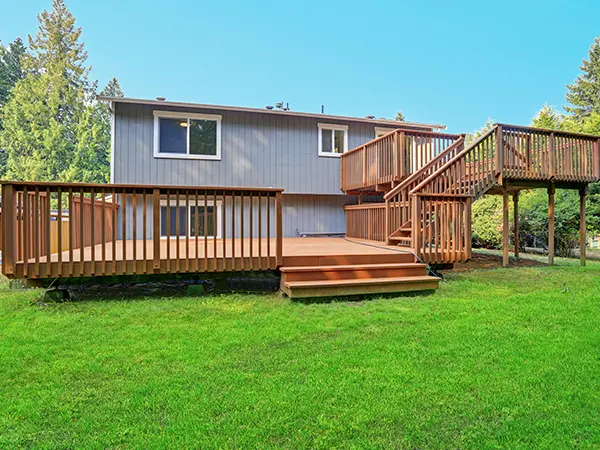 A large deck on two levels with wood railing